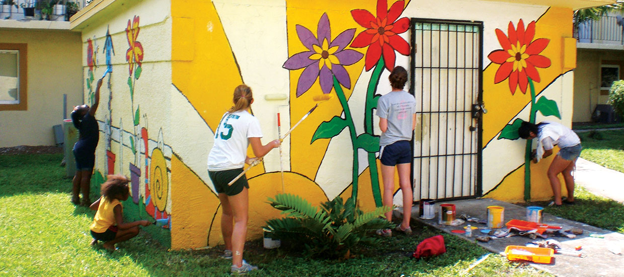 Students painting wall flowers
