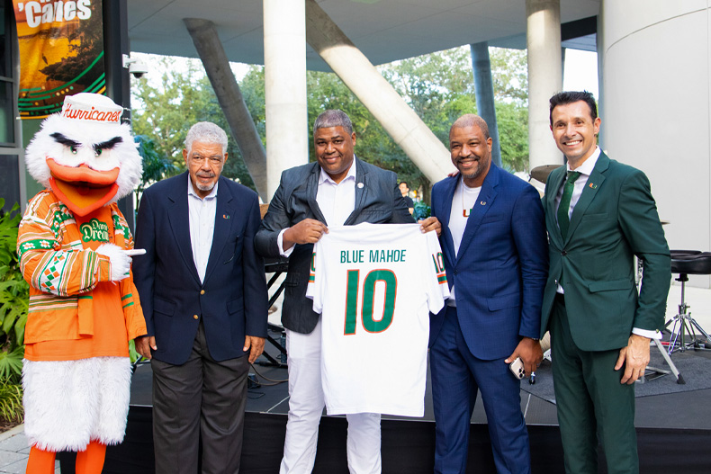 Sebastian the Ibis stands with, from left, Dr. Anthony Mullings, Robert Mullings, David Mullings, and Paul Pavlou, dean of the Miami Herbert Business School. Photo: Daniel Marquez.